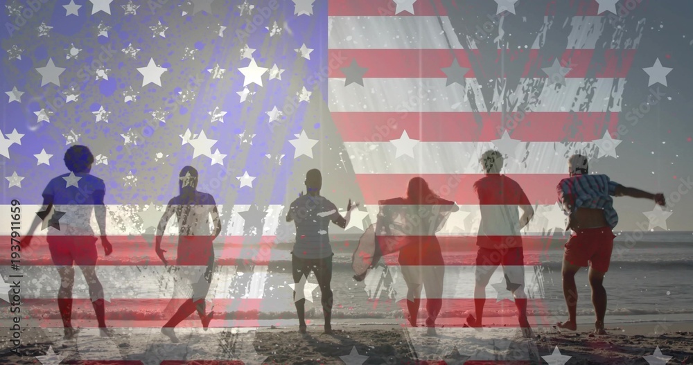 Fototapeta premium Walking group in swimwear along wet sand reflecting sun, carrying surfboard beneath flag overlay