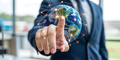 Businessmans hand touching a glowing interconnected digital globe symbolizing global network connections and technology