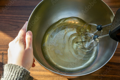 Whipping egg whites with hand mixer in metal bowl