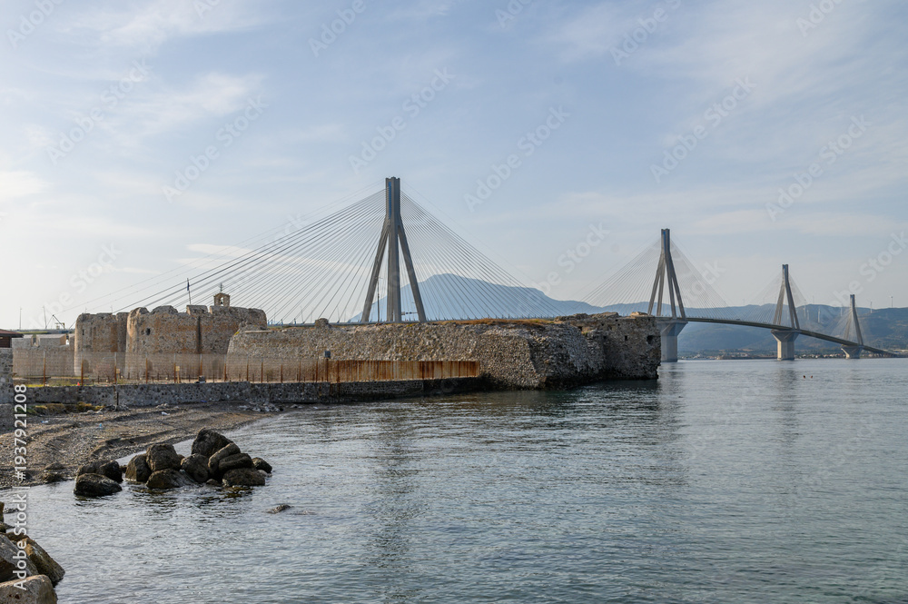 Obraz premium Contrast between ancient and modern architecture, Rio Fortress with Charilaos Trikoupis Rio Antirrio Bridge in background, Greece