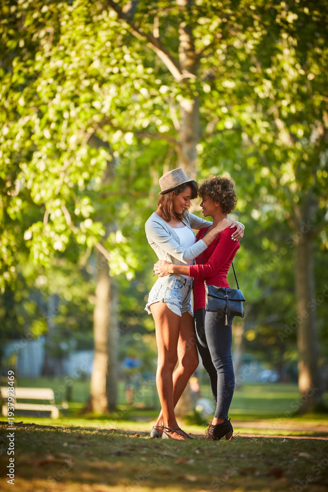 Fototapeta premium Nature, happy and lesbian couple hugging in park with bonding, love and care on vacation together. Smile, connection and lgbtq women embracing for trust in relationship outdoor on holiday with travel