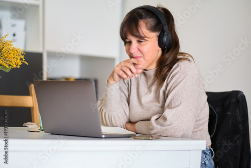Εκτύπωση καμβά Woman wearing headphones using laptop for remote work