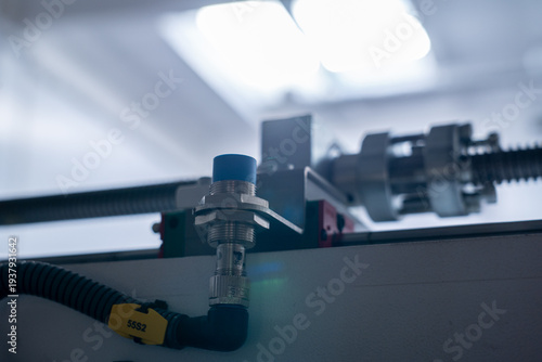 Industrial Proximity Sensor with Blue Cap Mounted on Automated Linear Guide