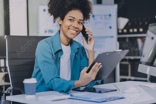 Young African American black woman working on laptop and mobile phone