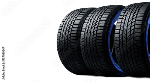 Four pristine black winter car tires with aggressive tread, sharply lit by cool blue rim light on a reflective black studio floor and matte background, high performance automotive advertising concept