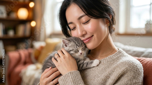 子猫を優しく抱きしめて頬ずりし、癒やしのひとときを過ごす日本人女性