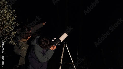 Obraz na plátne Learning about planets and stars in the deep night sky, two children stargazing