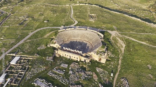 Cinematic aerial drone video of Hierapolis Antik Kenti and Pamukkale travertines in Denizli, Turkey, showcasing the Roman theater, columns, ruins, and dramatic landscape from above.