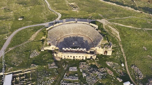Cinematic aerial drone video of Hierapolis Antik Kenti and Pamukkale travertines in Denizli, Turkey, showcasing the Roman theater, columns, ruins, and dramatic landscape from above.