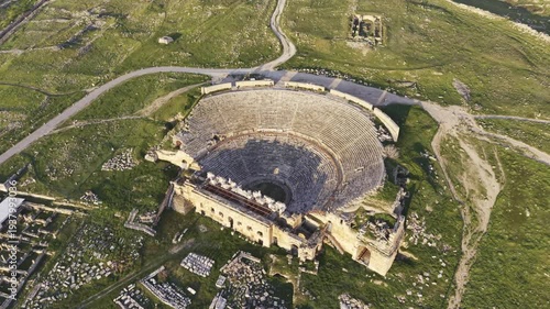 Cinematic aerial drone video of Hierapolis Antik Kenti and Pamukkale travertines in Denizli, Turkey, showcasing the Roman theater, columns, ruins, and dramatic landscape from above.