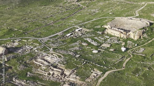 Cinematic aerial drone video of Hierapolis Antik Kenti and Pamukkale travertines in Denizli, Turkey, showcasing the Roman theater, columns, ruins, and dramatic landscape from above.