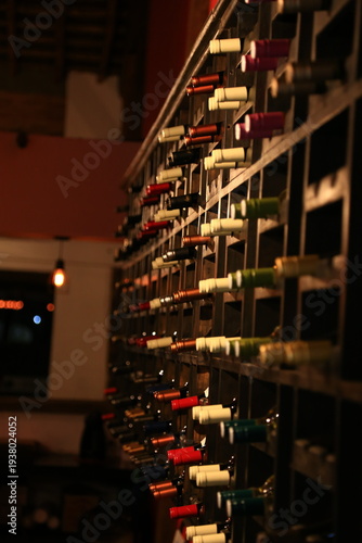 Estante de madera con botellas de vino tinto en bodega o vinoteca