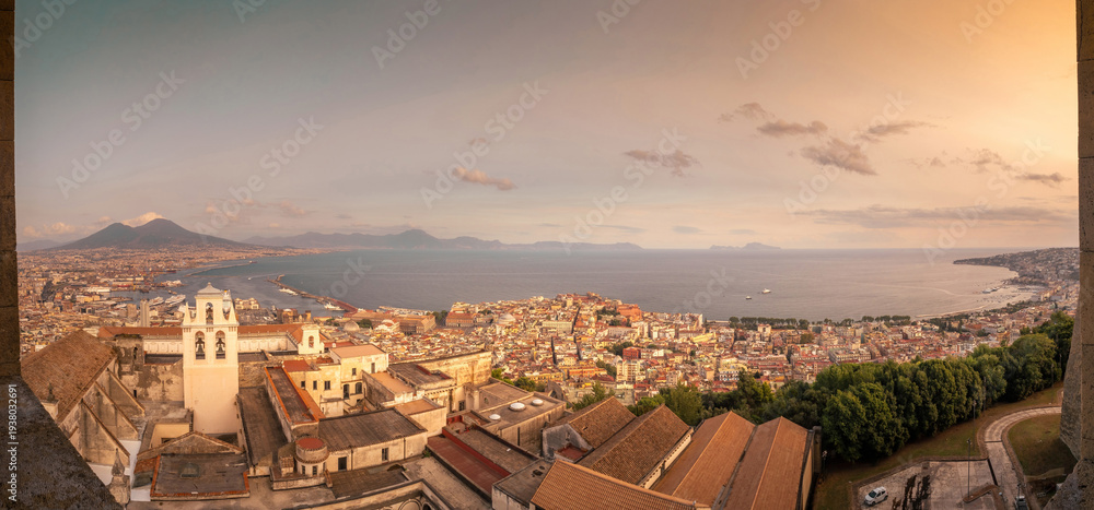 Obraz premium Golden sunset over Naples and the Bay of Naples seen from Castel Sant'Elmo, with Mount Vesuvius rising above the Mediterranean coast, Campania, Italy