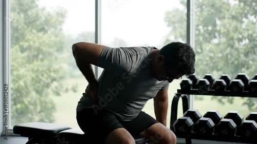 Man with back pain at gym.