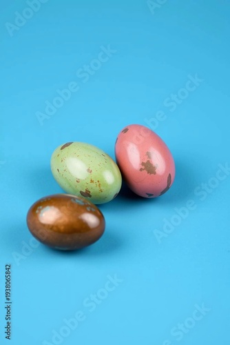 Brown, green and pink Easter eggs with gilding on a blue background