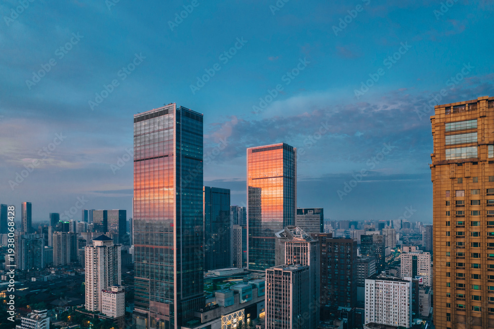 Fototapeta premium Modern skyscrapers reflecting sunrise glow in Chengdu cityscape