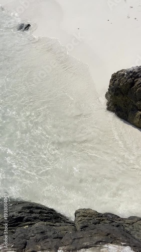 Waves crashing on rocky shore seaside beach aerial view tranquil environment natural beauty