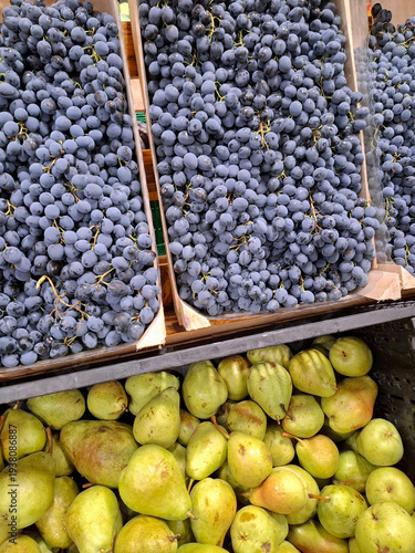 Blue grapes and green pears at grocery store