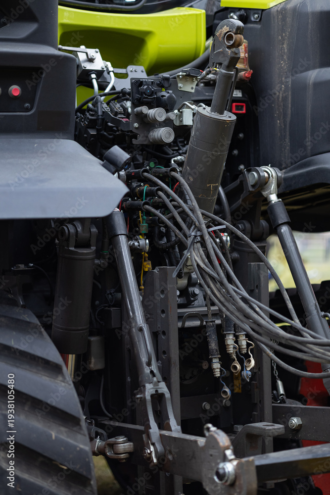 Fototapeta premium Detailed view of heavy duty three point hitch and hydraulic connections on a modern tractor for mounting farm implements. Preparation for spring field work and soil cultivation