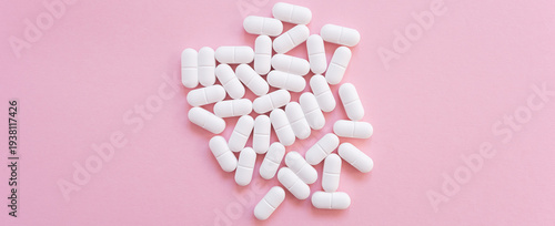 Tabletten or pillen in white package on the pink background with place for text.