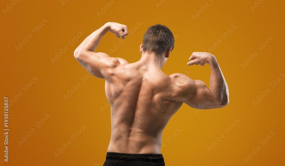 Obraz premium Handsome young sporty muscular man training in gym