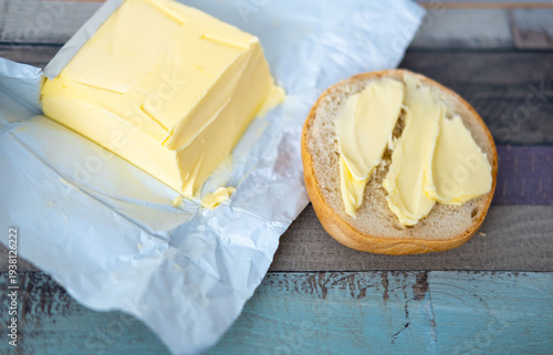 Canvastavla Close up fresh yellow butter being spread on toasted bread bun with metal knife,