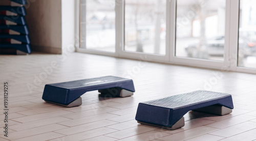 Blue aerobic step platforms in a bright fitness studio ready for workout and cardio training