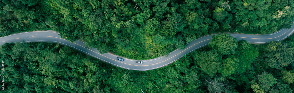 Fototapeta premium Aerial forest road with car creating abstract background for electric vehicle, ESG, sustainability and green investment business concepts.