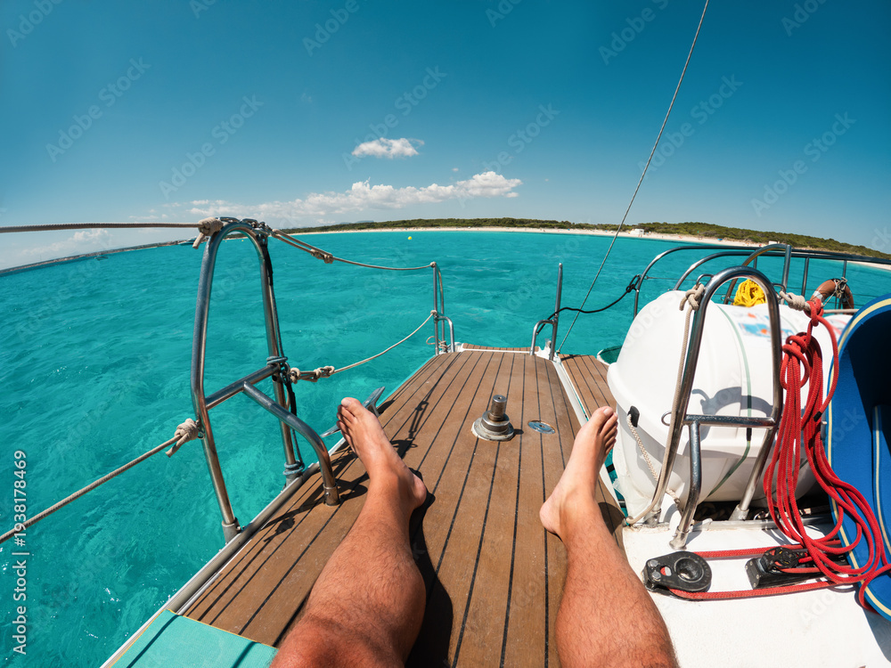 Obraz premium Legs view of male tourist enjoying boat catamaran tour during summer tour vacation - Travel, holidays and relax concept - UGC fisheye wide lens content - Main focus on feet