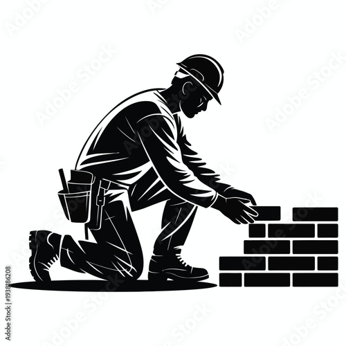 Construction worker building brick wall with safety gear and tools