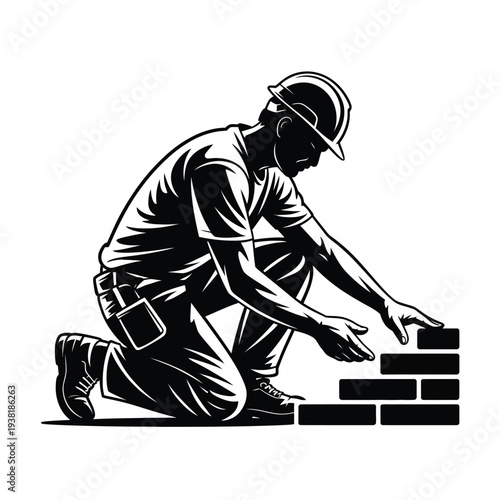 Construction worker building brick wall kneeling wearing hard hat focused on laying bricks precisely
