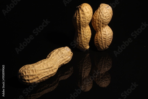Tableau sur toile Whole In shell peanuts isolated against a black background / Three 3 peanuts iso
