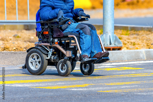Modern motorized wheelchair on a pedestrian zebra crossing, accessibility concept.Disabled person navigating urban environment.