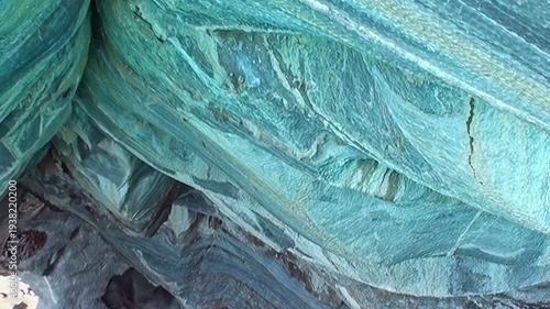 Explore the stunning Marble Caves of Patagonia. Turquoise waters reflect the intricately carved marble walls and arches, showcasing a natural wonder.