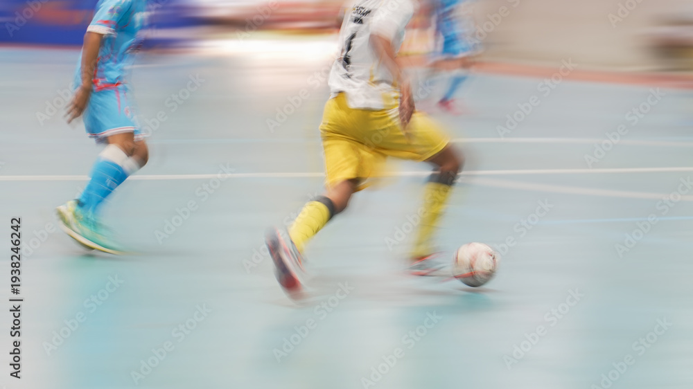 Fototapeta premium Speed and action: Blurred legs of soccer players during an indoor match