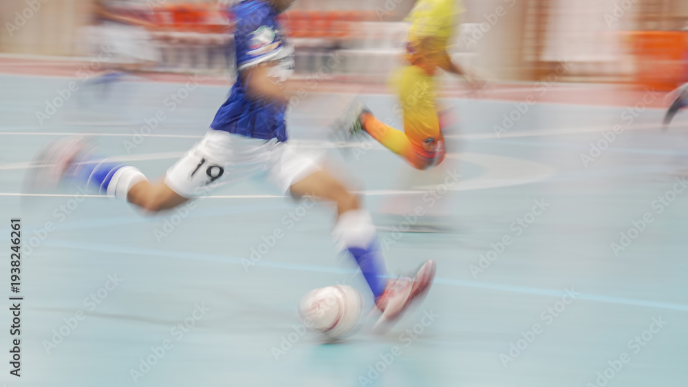 Naklejka premium Action shot of a futsal player kicking the ball toward the goal with motion blur