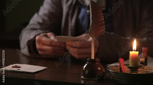 18th century man opening a letter to read focus on candle