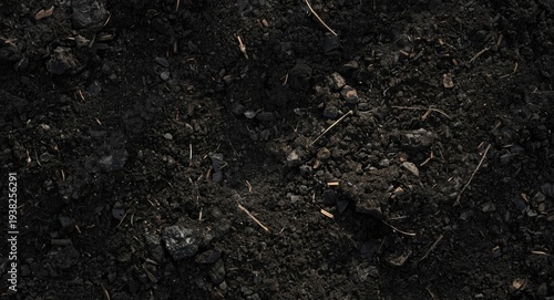 close up of dark textured soil with subtle roughness and soft daylight background