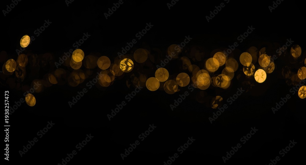 Obraz premium Black canvas with sparkling golden light bokeh effects in landscape layout and copy space for occasion greetings