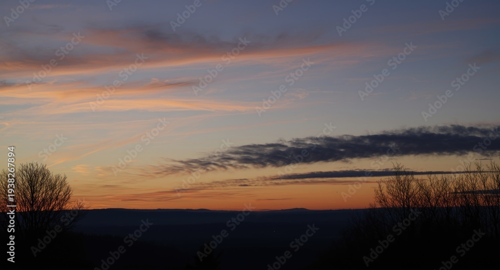 Obraz premium Winter evening sky glowing with golden twilight hues