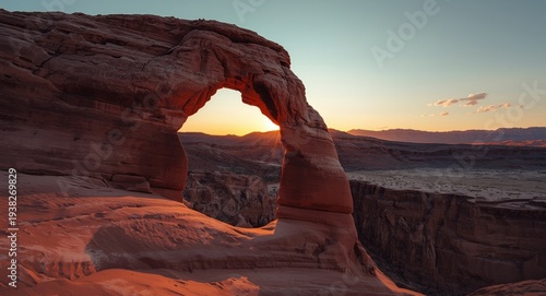 Evening light highlighting the curves of a natural arch in desert terrain