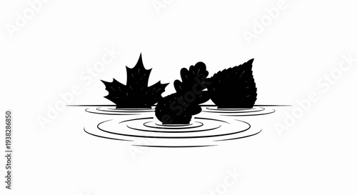 Silhouetted autumn leaves floating on rippling water