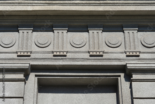 Obraz na płótnie Detailed view of a grey textured building facade featuring classical relief orna