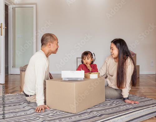 Asian family resting on moving day in new home