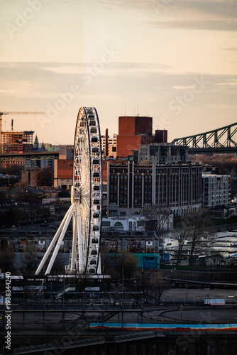 A picturesque view of a Ferris wheel juxtaposed against a city skyline at sunset, showcasing the leisure and excitement of urban attractions during golden hour.