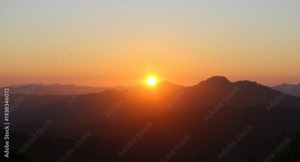 Obraz premium Sunrise panorama showcasing sunlit mountain tops in warm morning light