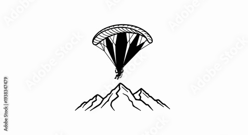 Silhouette of a paraglider soaring above jagged mountain peaks