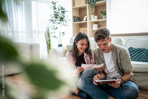 Slika na platnu Couple sharing memories viewing old photographs at home