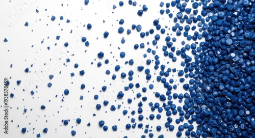 Close up of dark blue plastic masterbatch granules in multiple sizes on white surface