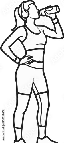 Athletic woman in headphones drinks from a water bottle after a workout